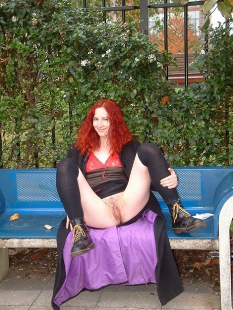 Redheaded girl plays with her hairless pussy on a bench in public 56608764